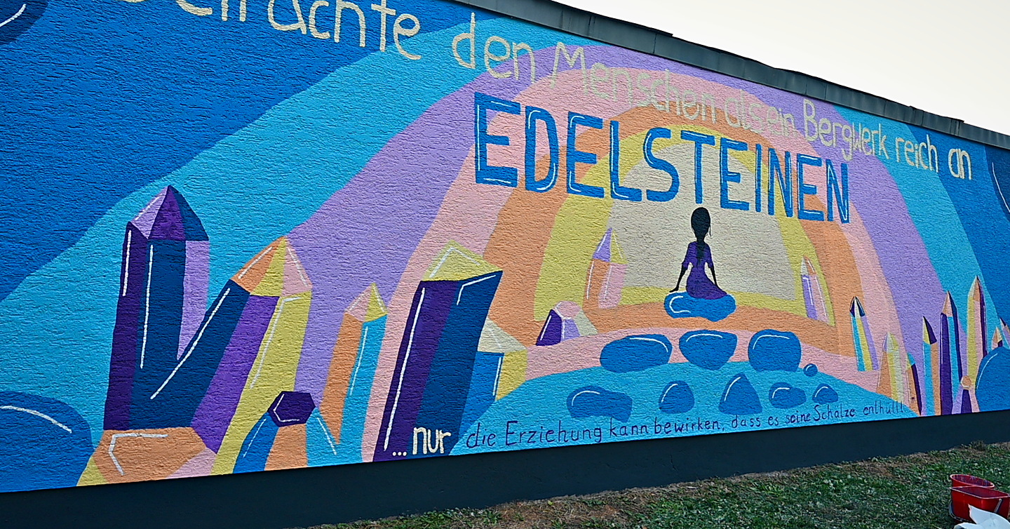 Seitlicher Blick auf die Edelsteinwand mit dem handgemalten Zitat
